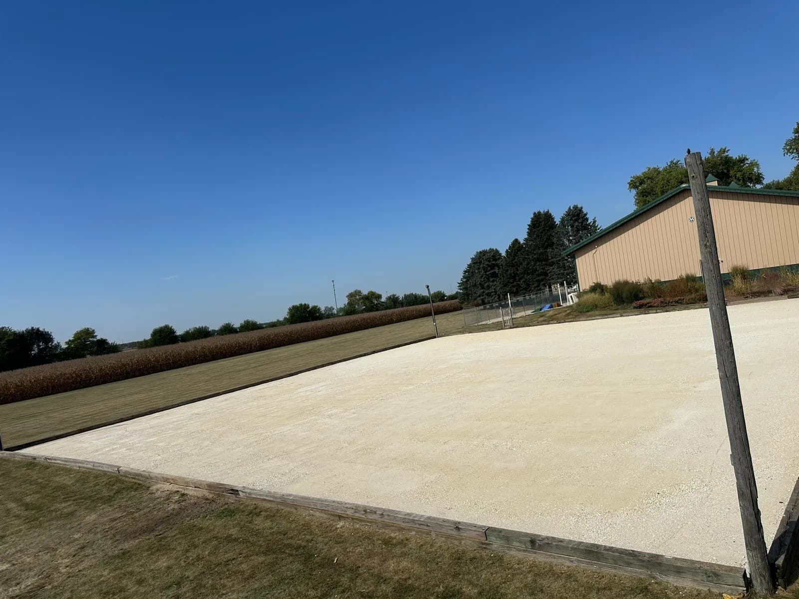 Large compacted gravel base pad graded and prepped beside a building by E.R. Hardscapes in Northern Illinois.