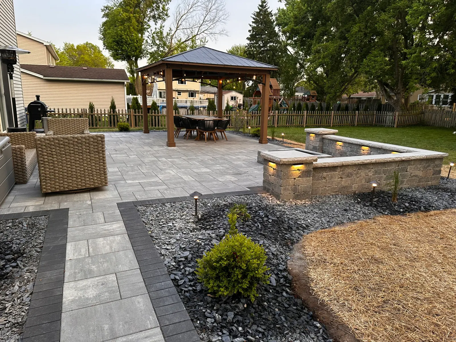 Full backyard transformation with a paver patio, walkway, seat wall, fire pit and new planting beds in Northern Illinois.